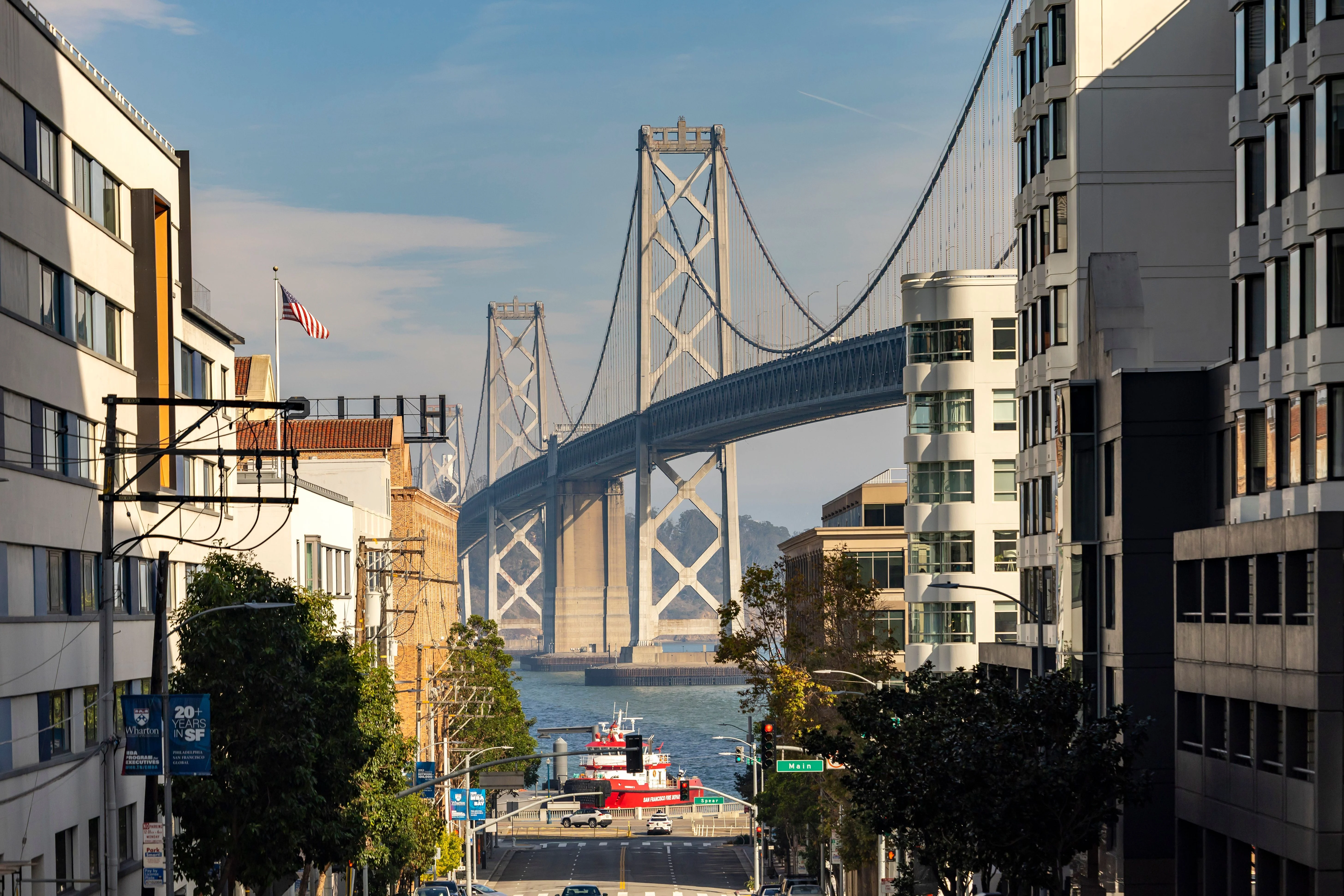 The San Francisco–Oakland Bay Bridge seen down a San Francisco street lined with buildings
